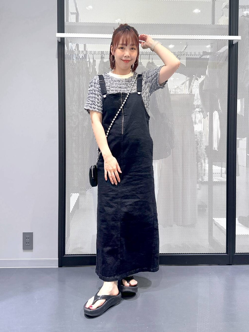 グレー系のジャンパースカート、ブラック系のサンダル、その他のTシャツ/カットソーを着用したレディースの夏コーディネートの2枚目の写真