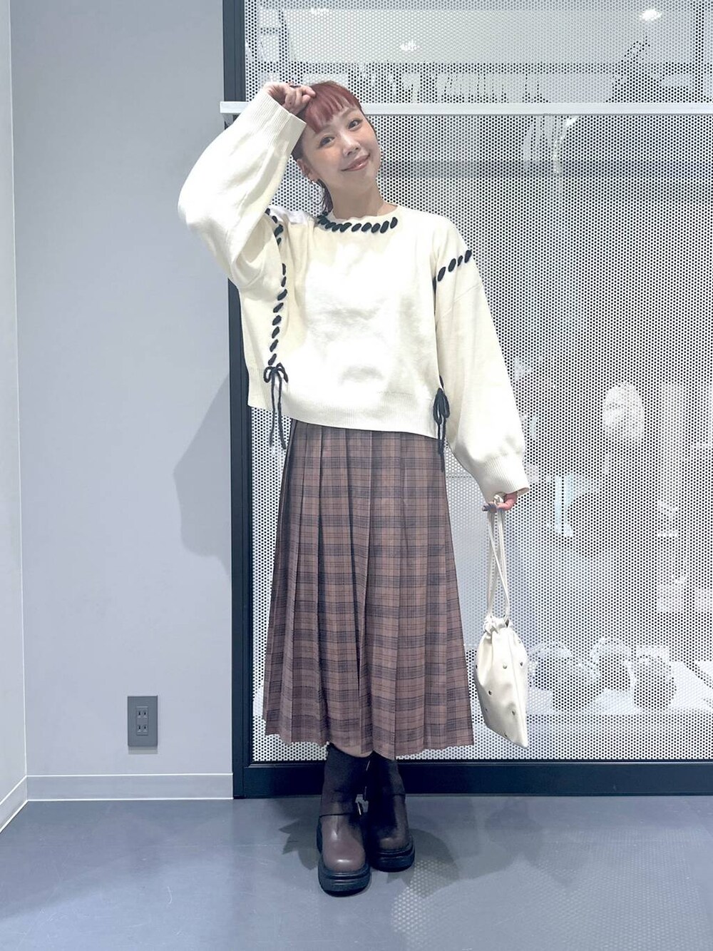 ホワイト系のショルダーバッグ、ブラック系のブルゾン、ブラウン系のブーツを着用したレディースの秋コーディネートの3枚目の写真