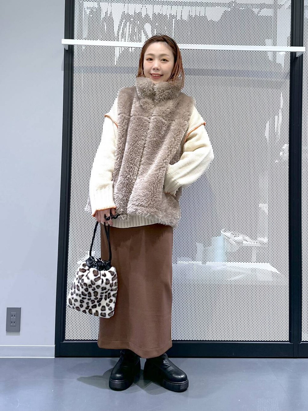 ホワイト系のブルゾン、その他のショルダーバッグ、ブラック系のブーツを着用したレディースの冬コーディネートの4枚目の写真