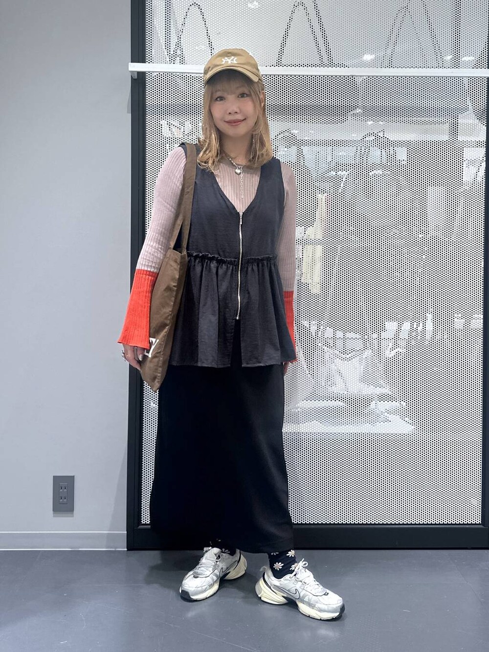 ブラック系のスカート、ブラウン系のトートバッグ、ブラウン系のニット/セーターを着用したレディースの秋コーディネートの2枚目の写真