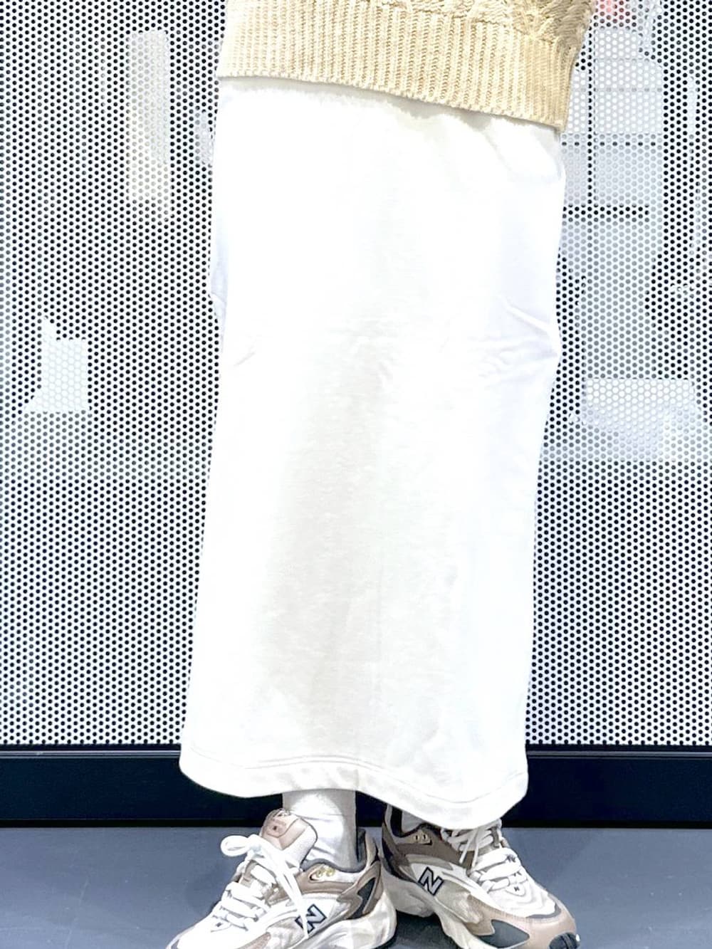 ブラウン系のスニーカー、ベージュ系のショルダーバッグ、グリーン系のナイロンジャケットを着用したレディースの冬コーディネートの9枚目の写真