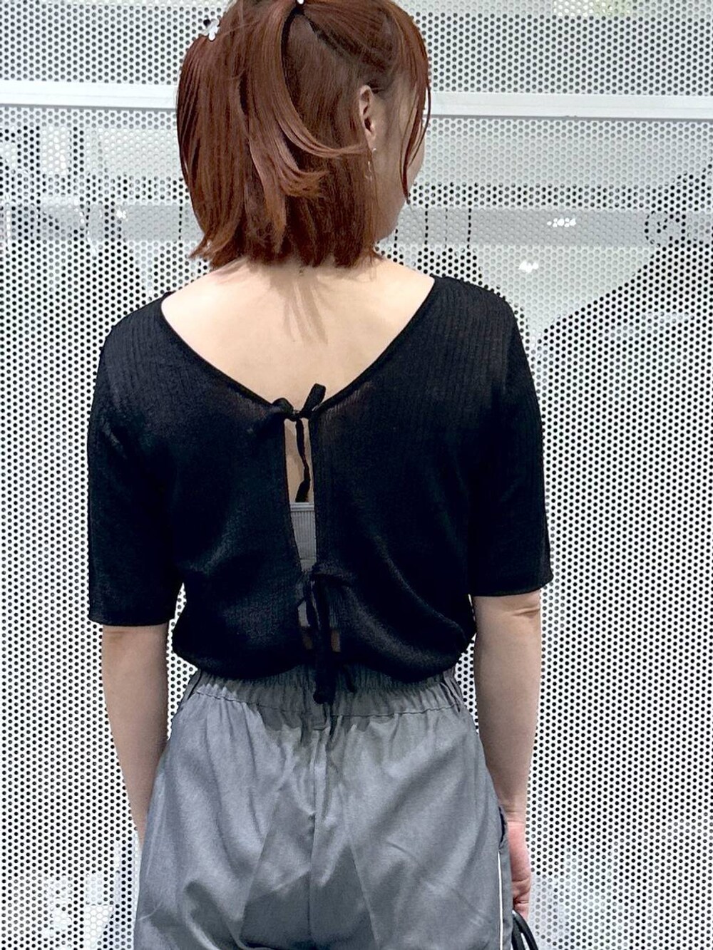 ブラック系のショルダーバッグ、ブラック系のカーディガン/ボレロ、グレー系のスラックスを着用したレディースの夏コーディネートの6枚目の写真