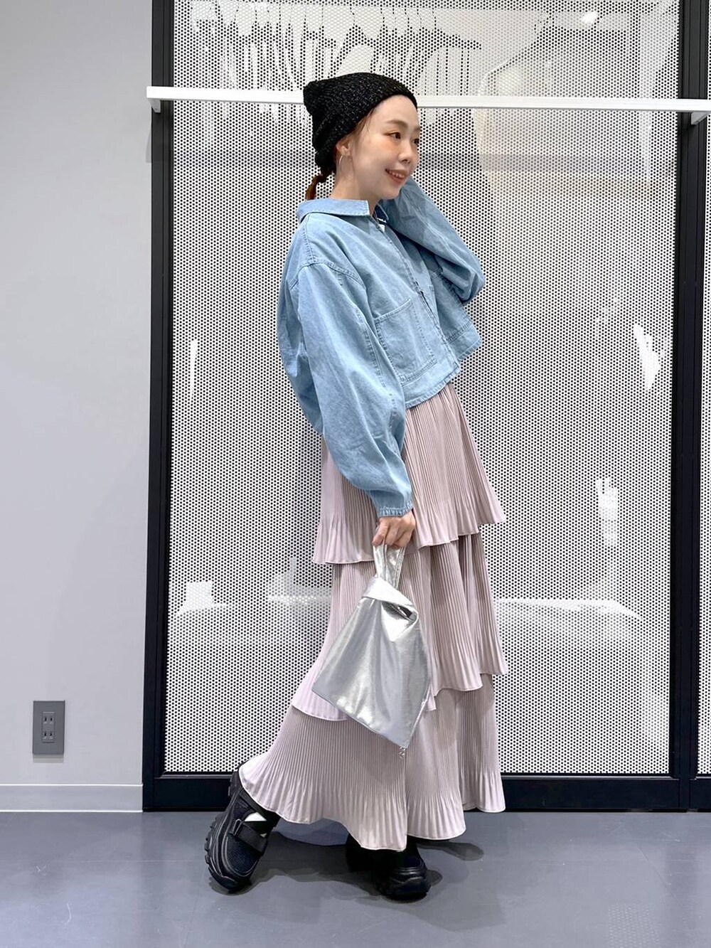 ブラック系のスニーカー、ブルー系のデニムジャケット、シルバー系のショルダーバッグを着用したレディースの春コーディネートの3枚目の写真