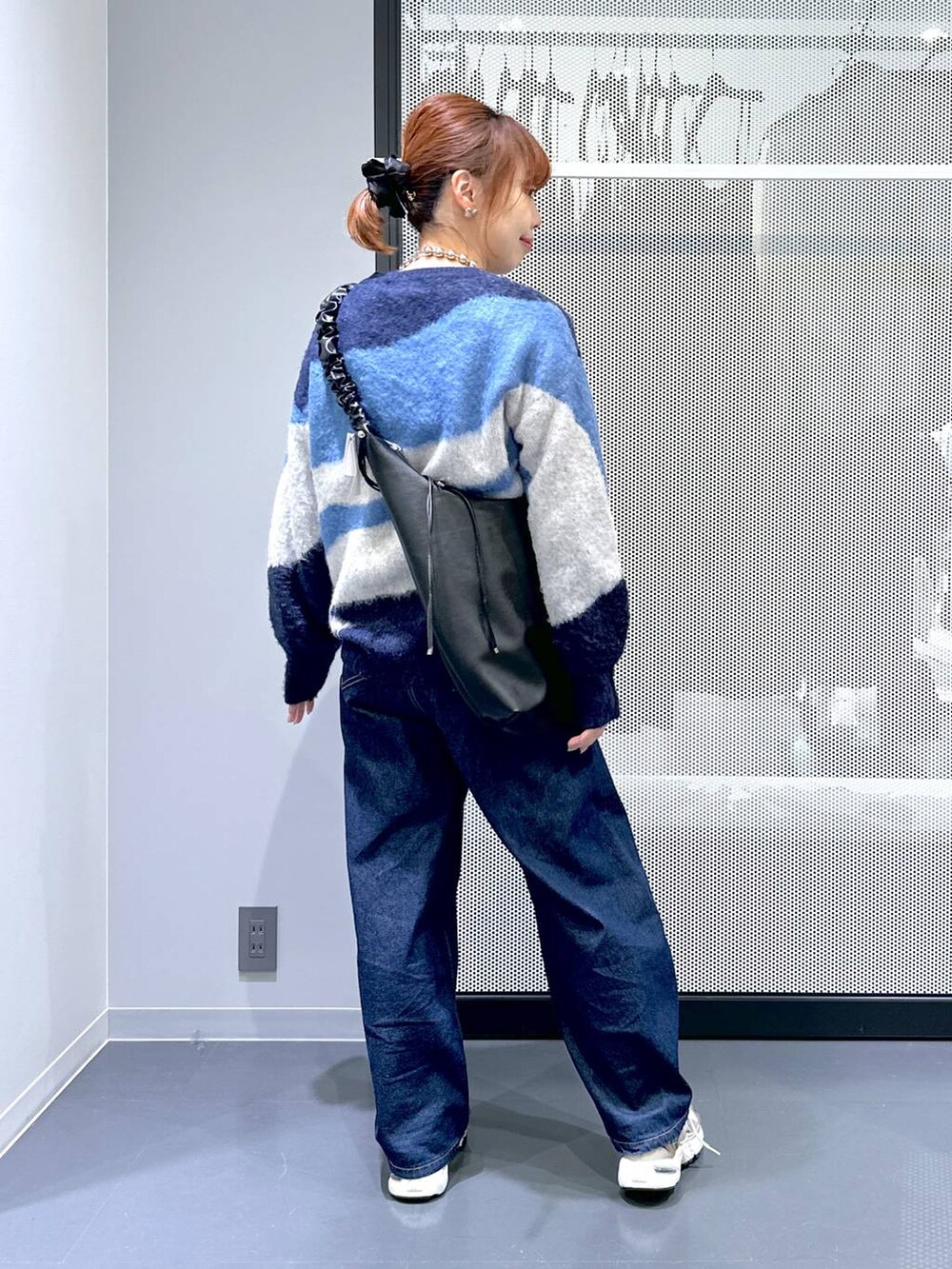 ブラウン系のスニーカー、ホワイト系のTシャツ/カットソー、ブルー系のデニムパンツを着用したレディースの冬コーディネートの4枚目の写真