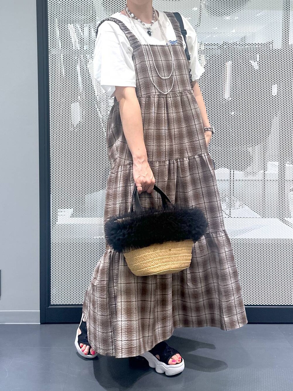 ベージュ系のショルダーバッグ、ブラウン系のワンピース、ブラック系のサンダルを着用したレディースの春コーディネートの3枚目の写真