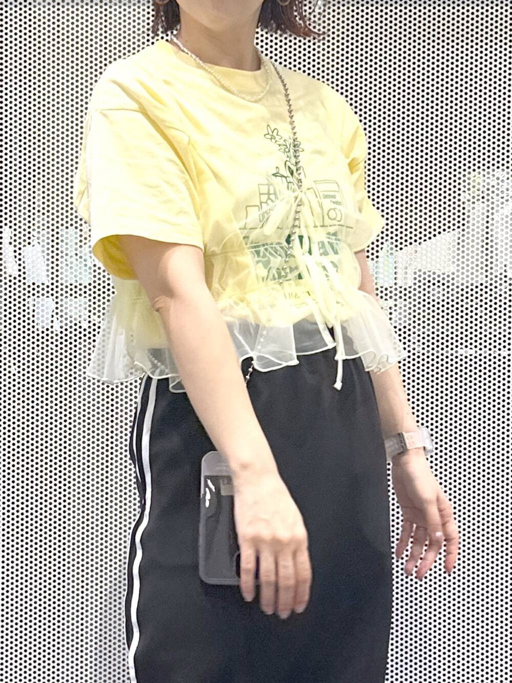 ブラック系のスカート、イエロー系のキャミソール、ベージュ系のTシャツ/カットソーを着用したレディースの春コーディネートの6枚目の写真