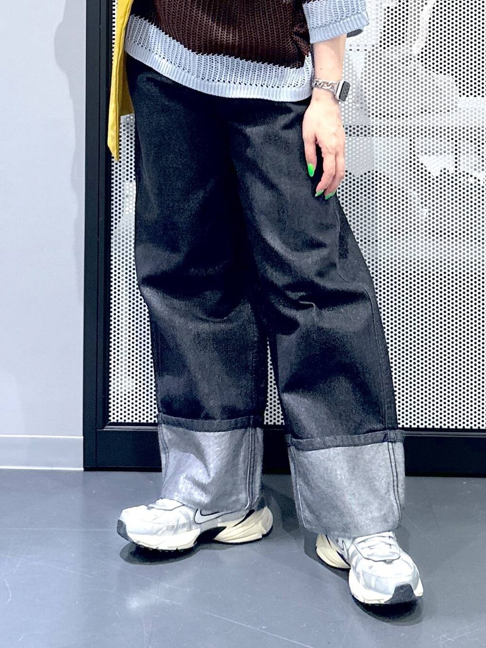 ブラック系のデニムパンツ、イエロー系のトートバッグ、ブルー系のニット/セーターを着用したレディースの春コーディネートの5枚目の写真