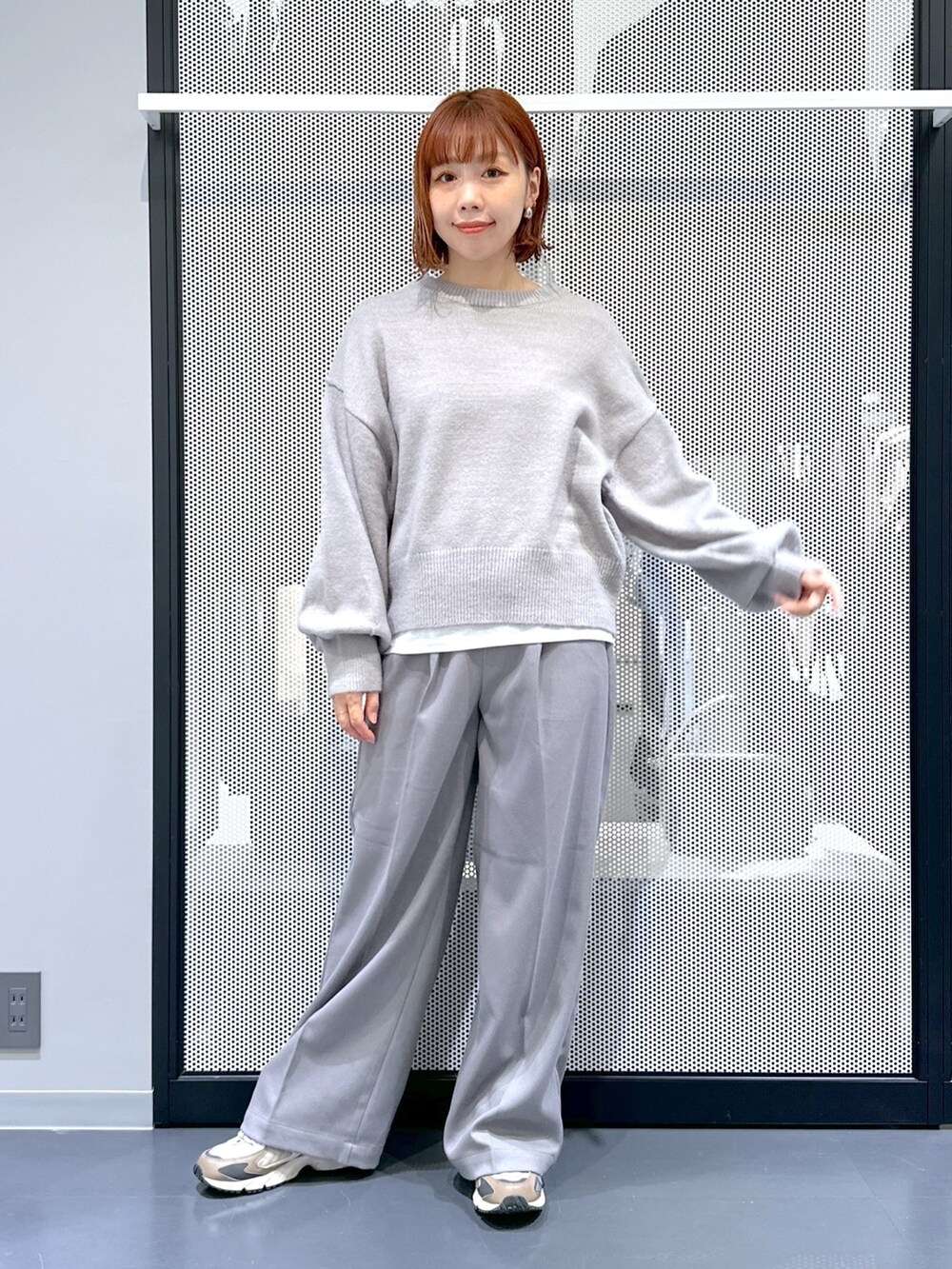 ブラック系のナイロンジャケット、グレー系のニット/セーター、ホワイト系のTシャツ/カットソーを着用したレディースの秋コーディネートの2枚目の写真