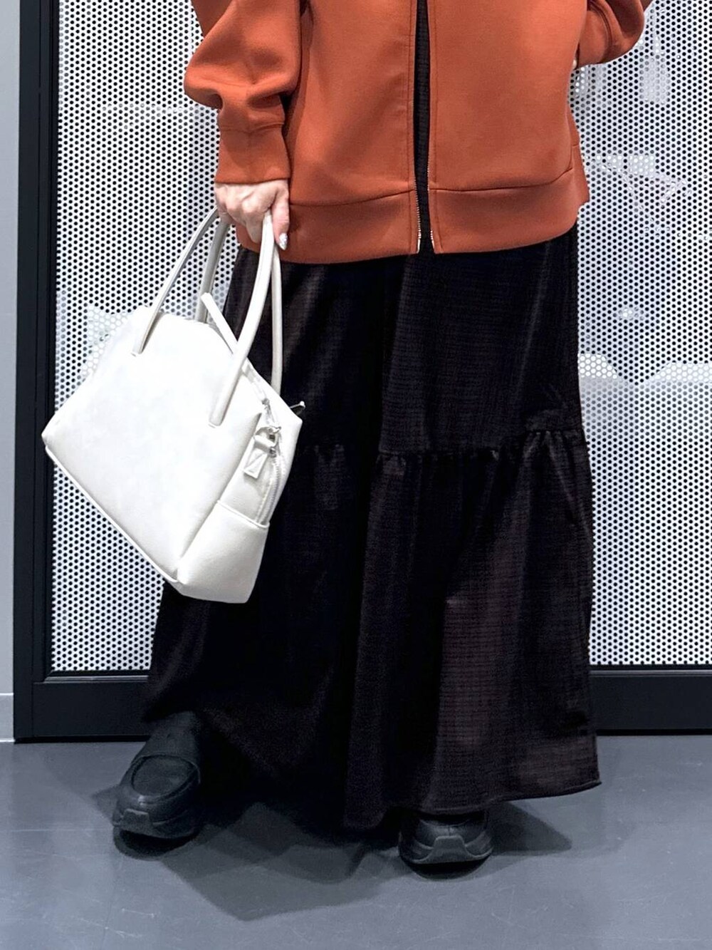 グレー系のボストンバッグ、ブラウン系のパーカー、ホワイト系のTシャツ/カットソーを着用したレディースの秋コーディネートの5枚目の写真