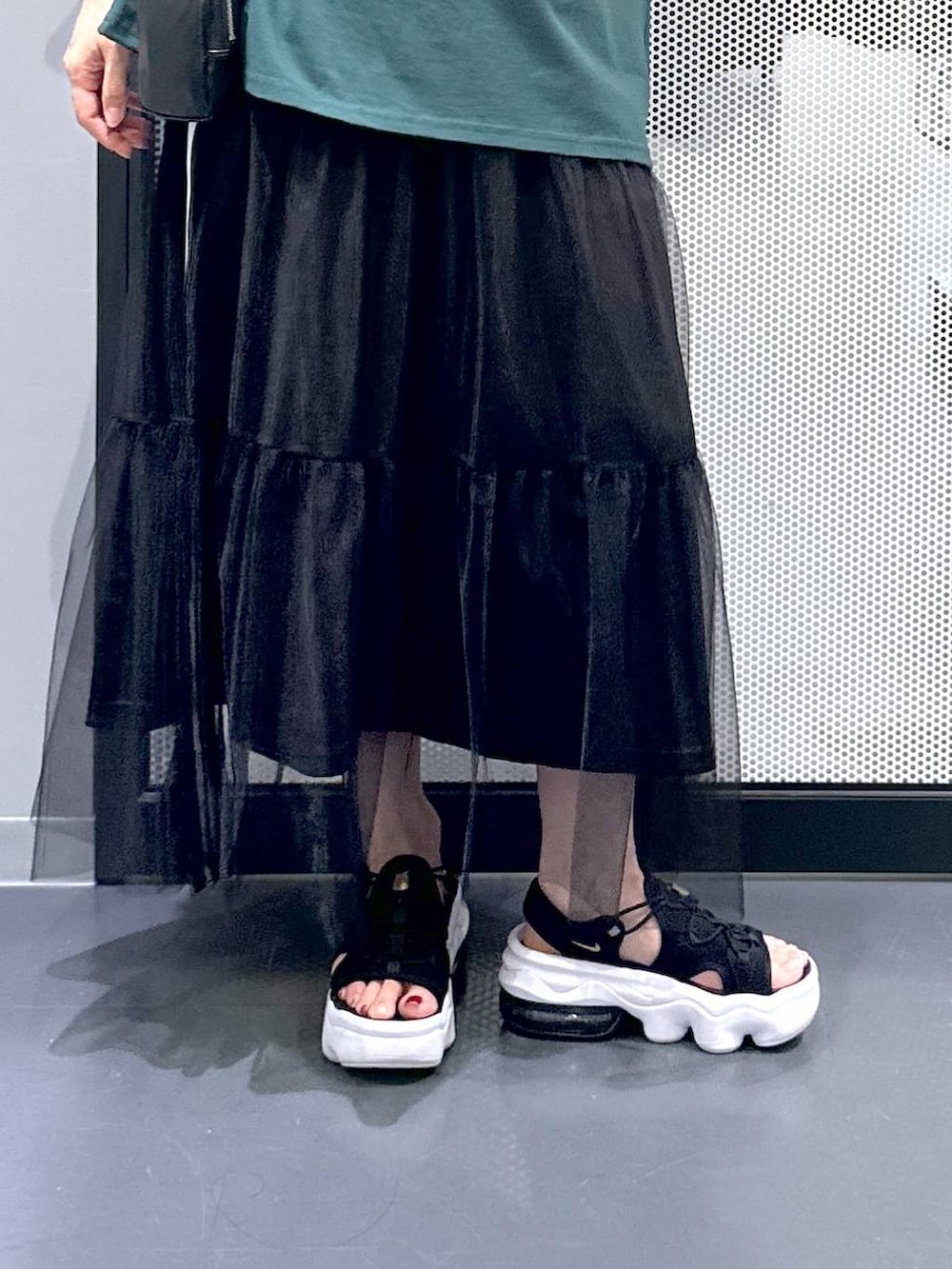 ブラック系のスカート、グリーン系のTシャツ/カットソー、その他のネックレスを着用したレディースの夏コーディネートの5枚目の写真