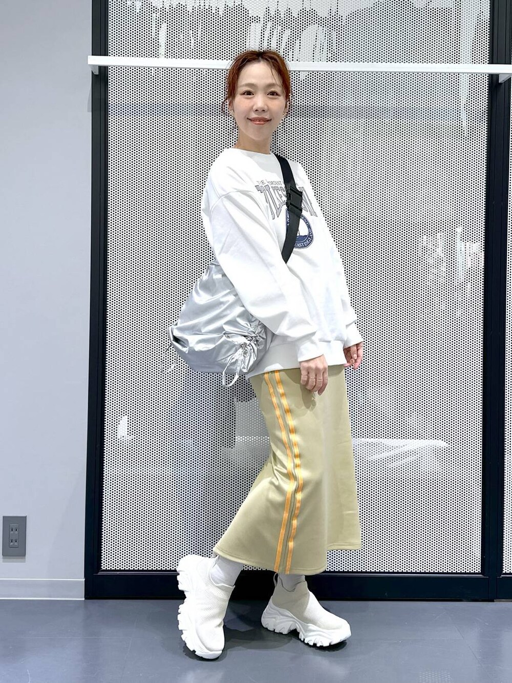 グリーン系のスカート、シルバー系のショルダーバッグ、ブラック系のシュシュを着用したレディースの冬コーディネートの5枚目の写真