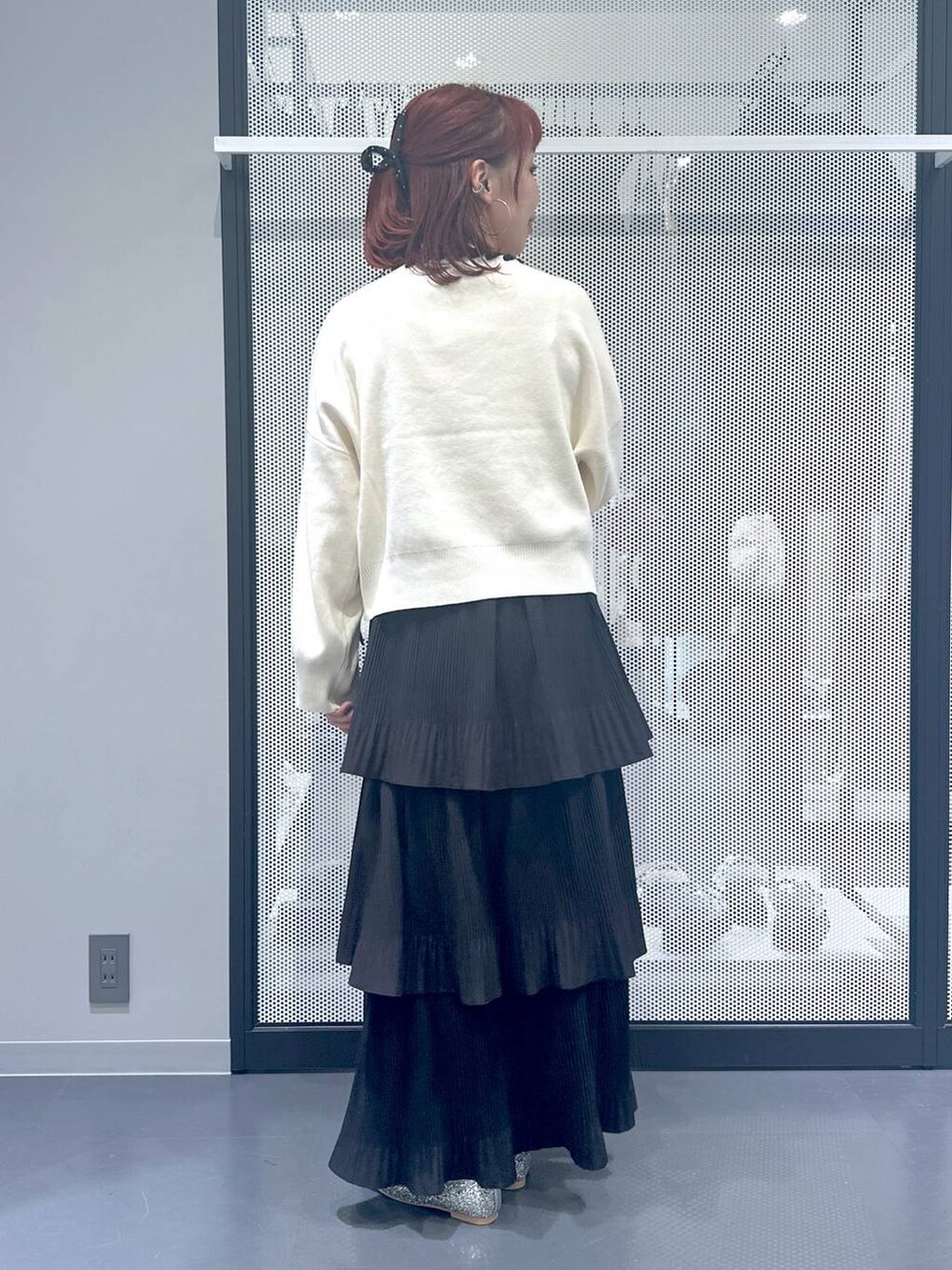 ブラック系のスカート、ブラック系のショルダーバッグ、シルバー系のパンプスを着用したレディースの秋コーディネートの3枚目の写真