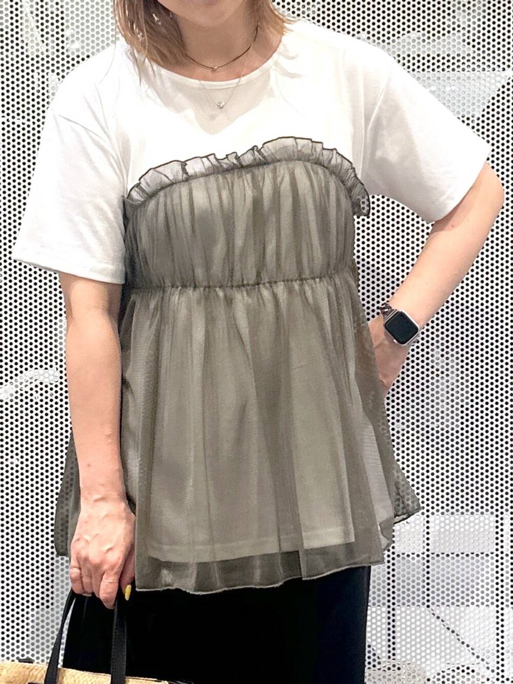 ベージュ系のショルダーバッグ、ブラック系のスカート、グリーン系のTシャツ/カットソーを着用したレディースの春コーディネートの3枚目の写真