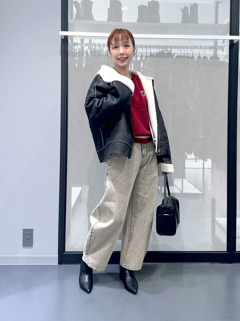 ブラック系のショルダーバッグ、ブラック系のブルゾン、ベージュ系のデニムパンツを着用したレディースの秋コーディネートの9枚目の写真