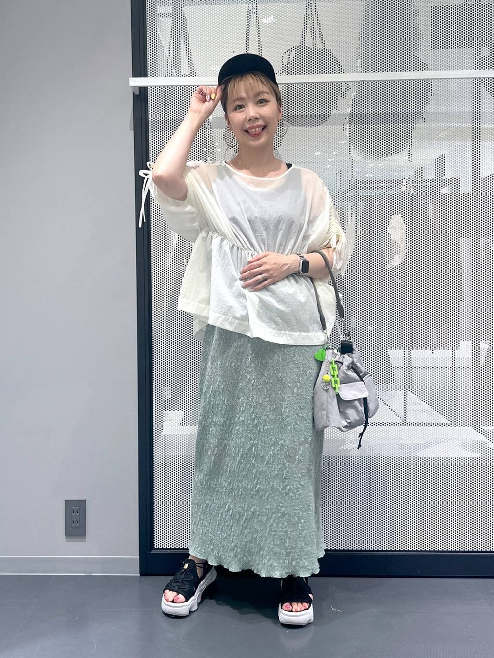 ブラック系のタンクトップ、グレー系のショルダーバッグ、グリーン系のスカートを着用したレディースの夏コーディネートの6枚目の写真