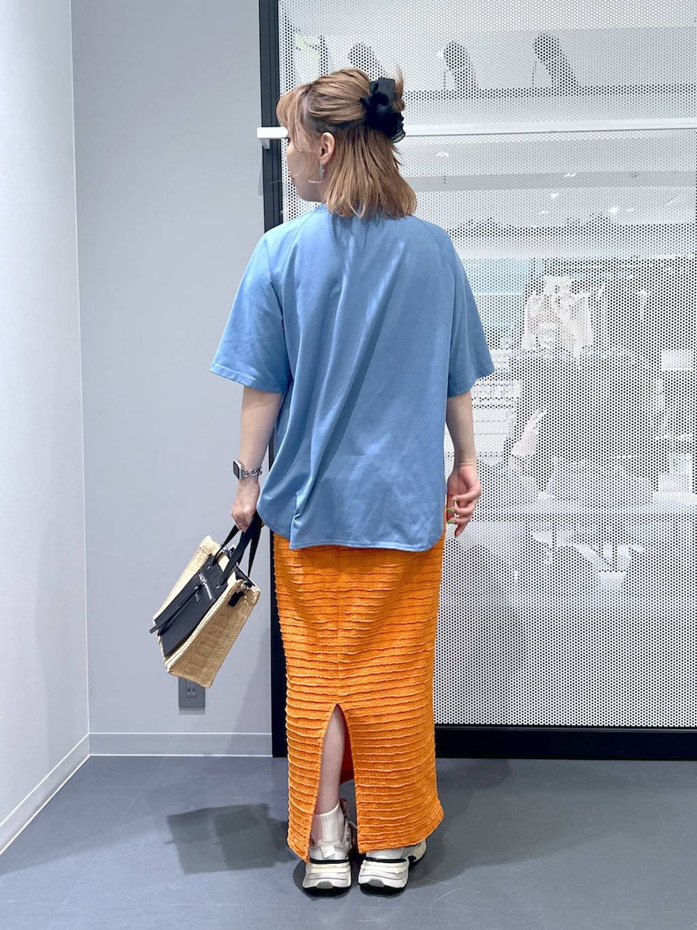 ベージュ系のショルダーバッグ、オレンジ系のスカート、ブルー系のTシャツ/カットソーを着用したレディースの春コーディネートの3枚目の写真