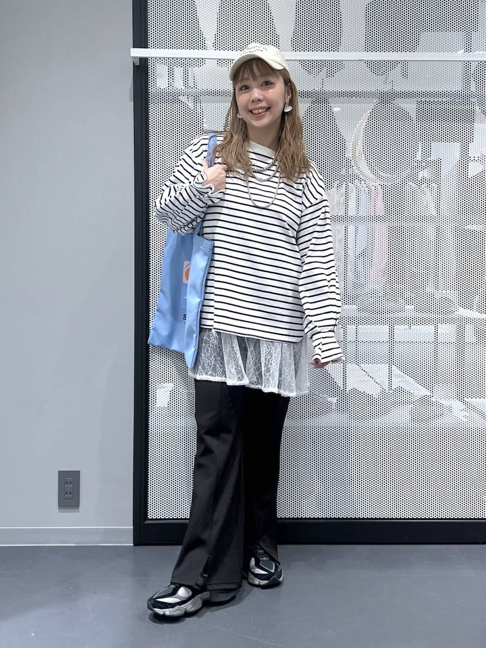 ブルー系のトートバッグ、ブラック系のその他パンツ、ホワイト系のワンピースを着用したレディースの春コーディネートの2枚目の写真