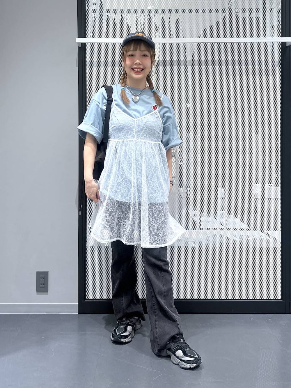 ブラック系のデニムパンツ、ブラック系のバックパック/リュック、ホワイト系のワンピースを着用したレディースの夏コーディネートの2枚目の写真