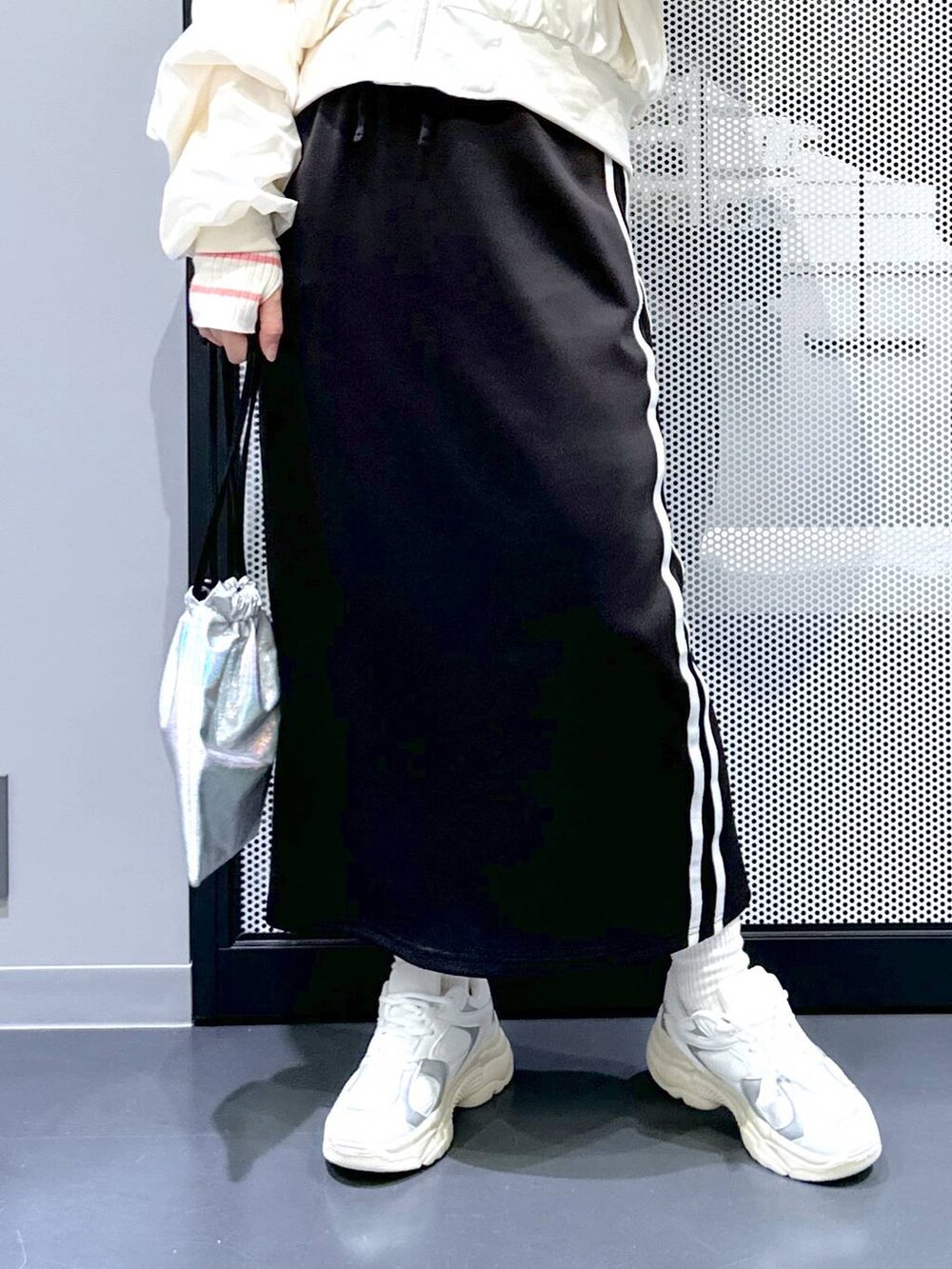 ブラック系のスカート、ベージュ系のMA-1、ピンク系のニット/セーターを着用したレディースの冬コーディネートの4枚目の写真