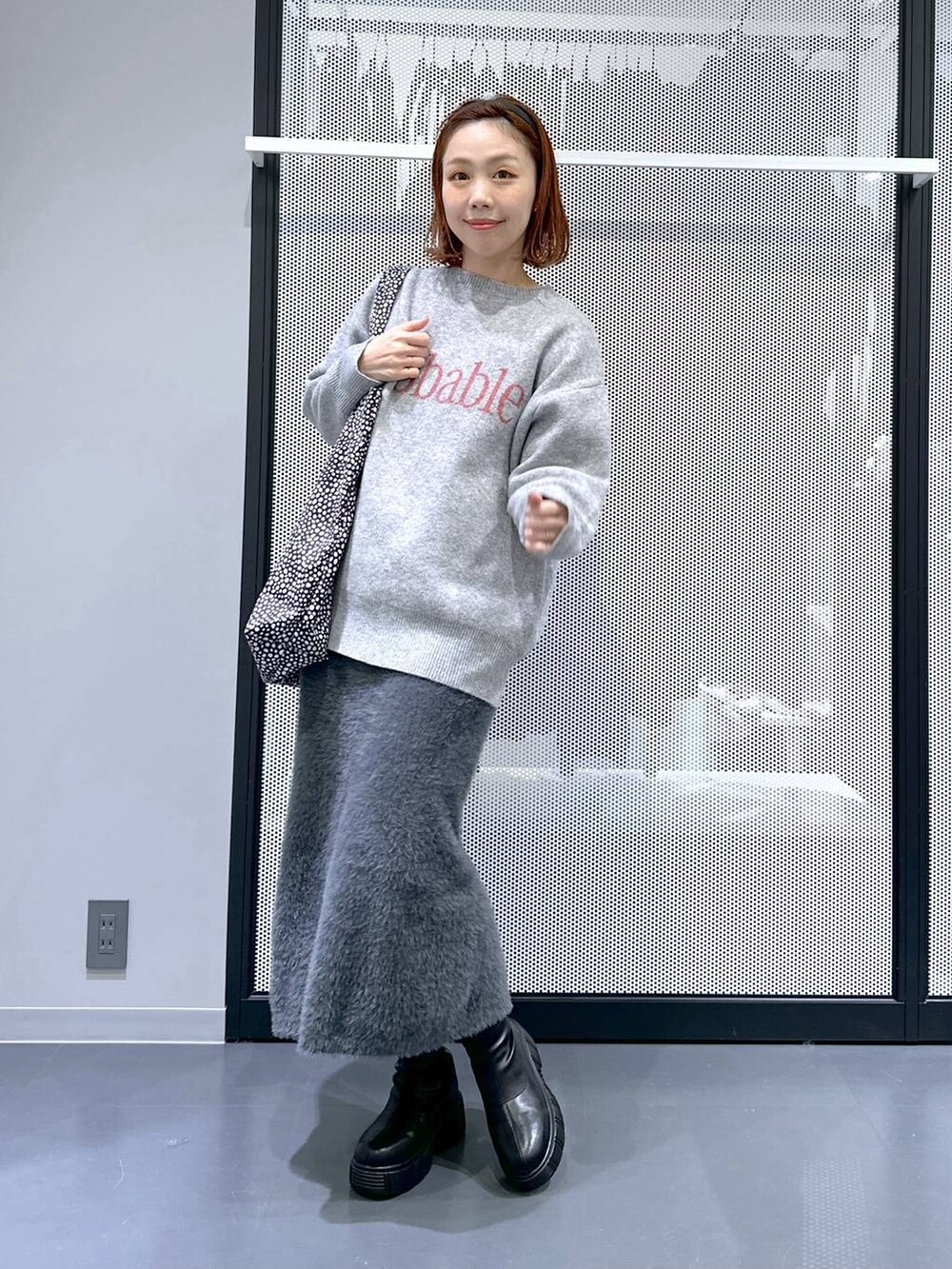 ブラック系のトートバッグ、ブラック系のブーツ、ブラック系のブルゾンを着用したレディースの冬コーディネートの2枚目の写真