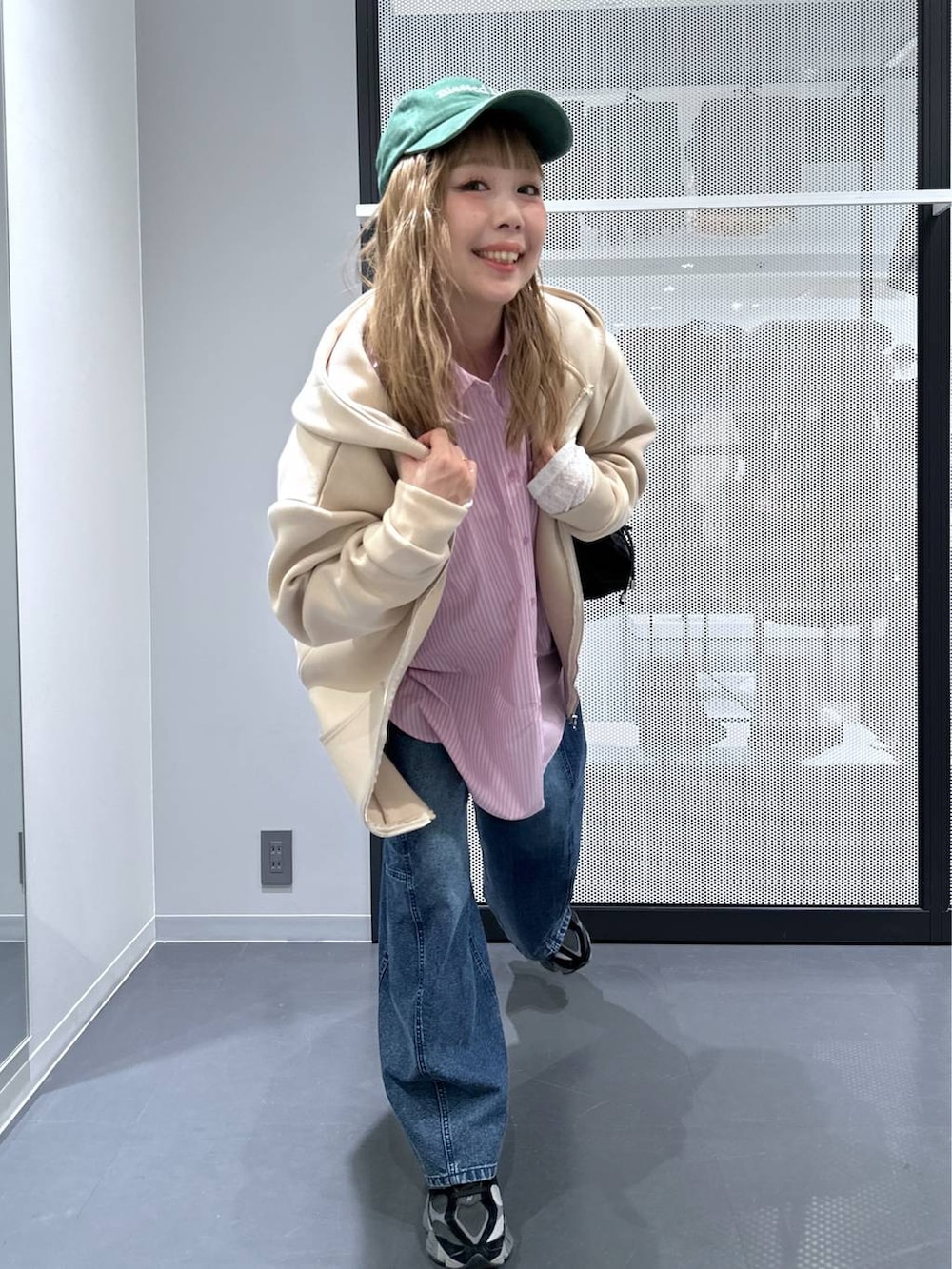 ホワイト系のTシャツ/カットソー、ブラック系のショルダーバッグ、ブルー系のデニムパンツを着用したレディースの冬コーディネートの8枚目の写真