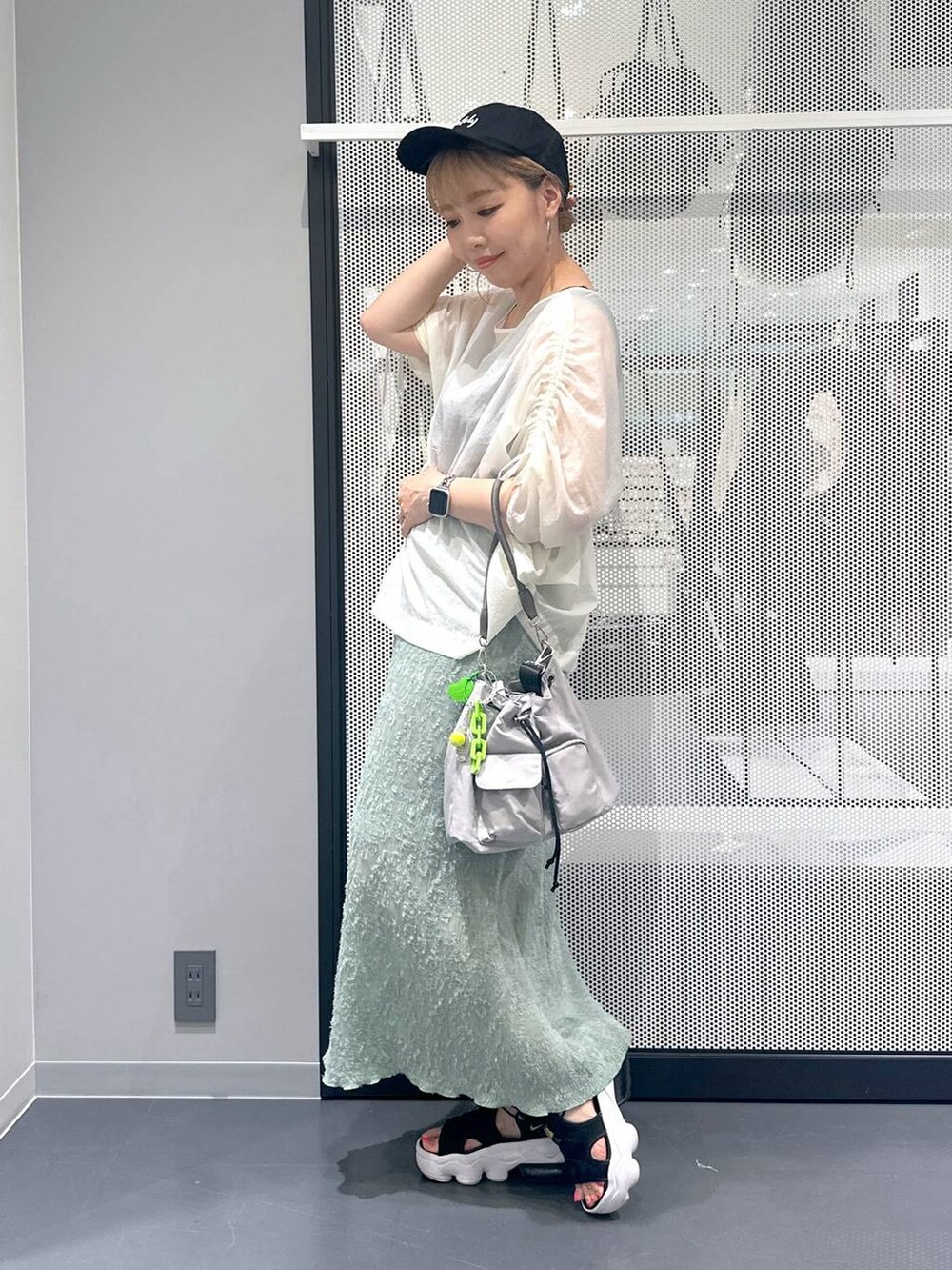 ブラック系のタンクトップ、グレー系のショルダーバッグ、グリーン系のスカートを着用したレディースの夏コーディネートの2枚目の写真