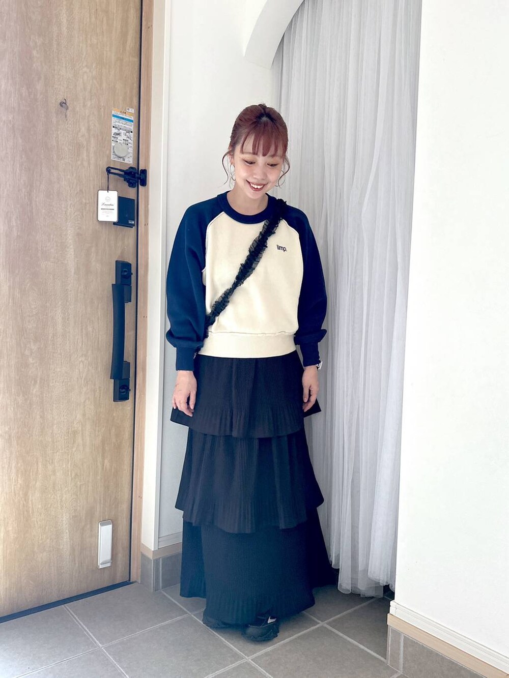 ブラック系のスカート、グレー系のスニーカー、ブルー系のニット/セーターを着用したレディースの秋コーディネートの6枚目の写真