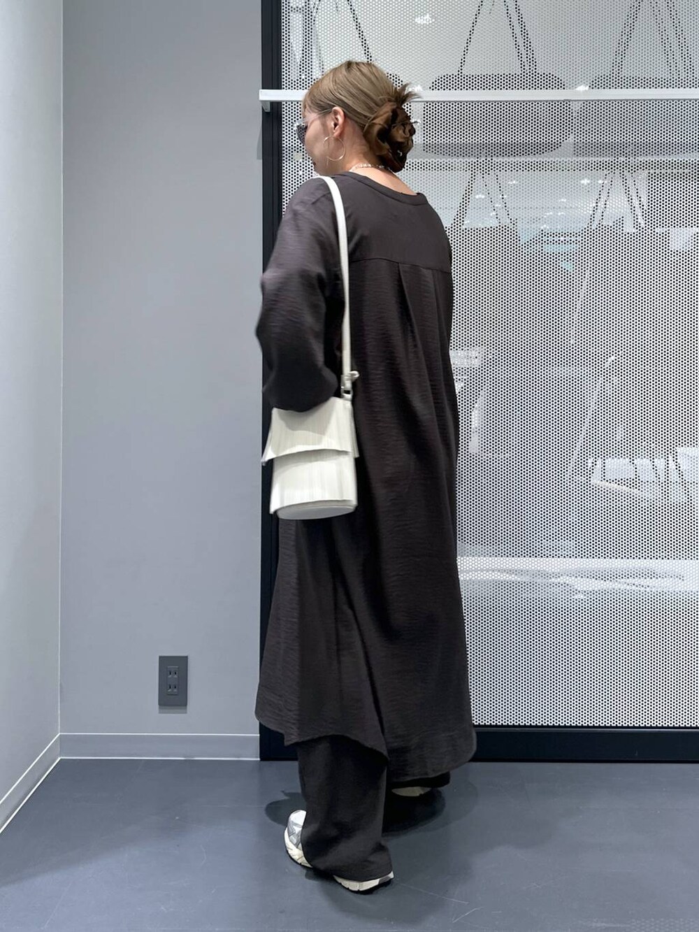 グレー系のその他パンツ、ホワイト系のタンクトップ、ホワイト系のショルダーバッグを着用したレディースの秋コーディネートの3枚目の写真