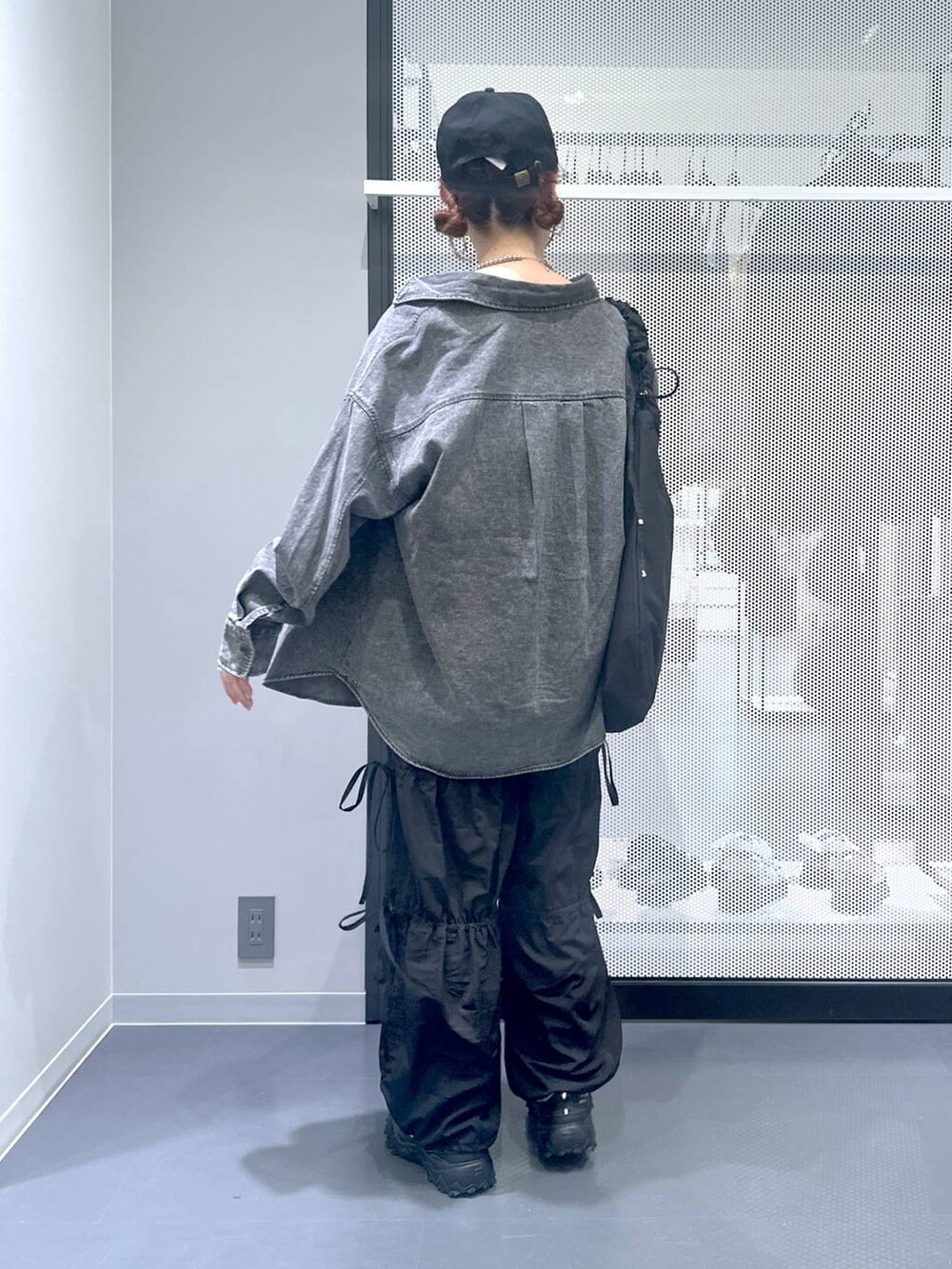 グレー系のスニーカー、ブラック系のショルダーバッグ、ブラック系のその他パンツを着用したレディースの秋コーディネートの4枚目の写真