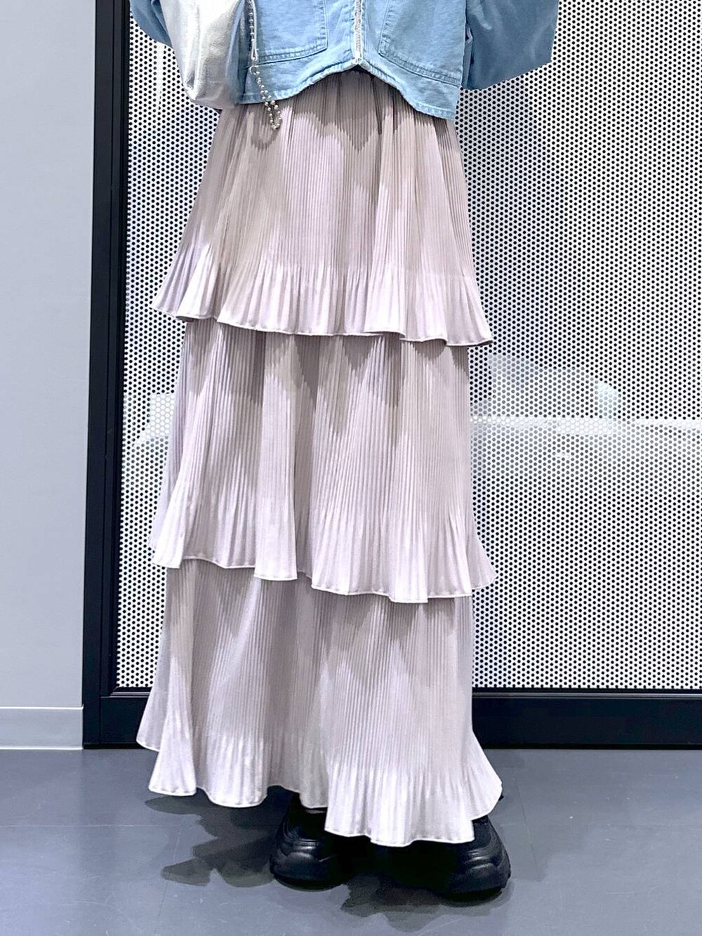 ブラック系のスニーカー、ブルー系のデニムジャケット、シルバー系のショルダーバッグを着用したレディースの春コーディネートの7枚目の写真