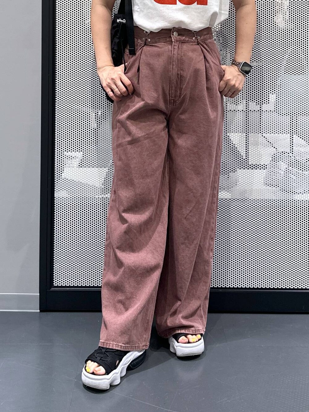 ブラック系のショルダーバッグ、ホワイト系のTシャツ/カットソー、ブラウン系のデニムパンツを着用したレディースの夏コーディネートの5枚目の写真