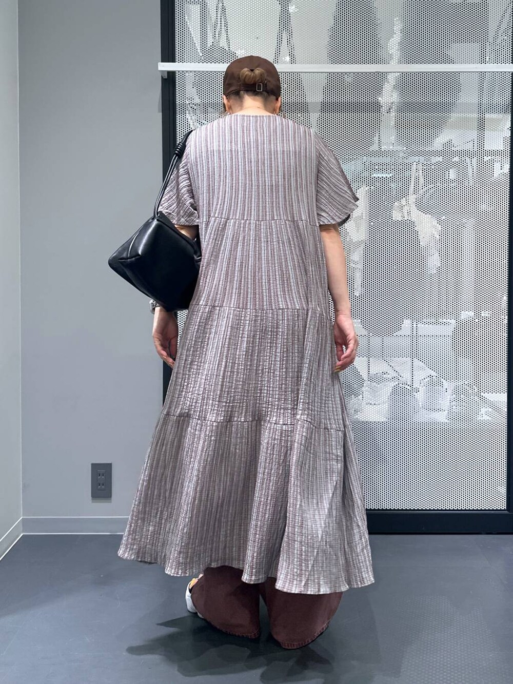 ホワイト系のキャミソール、グレー系のワンピース、ブラック系のショルダーバッグを着用したレディースの夏コーディネートの3枚目の写真