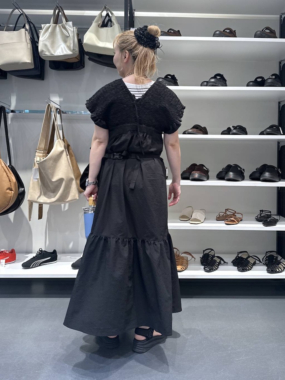 ブラック系のワンピース、シルバー系のデジタル腕時計、オレンジ系の水筒を着用したレディースの夏コーディネートの4枚目の写真