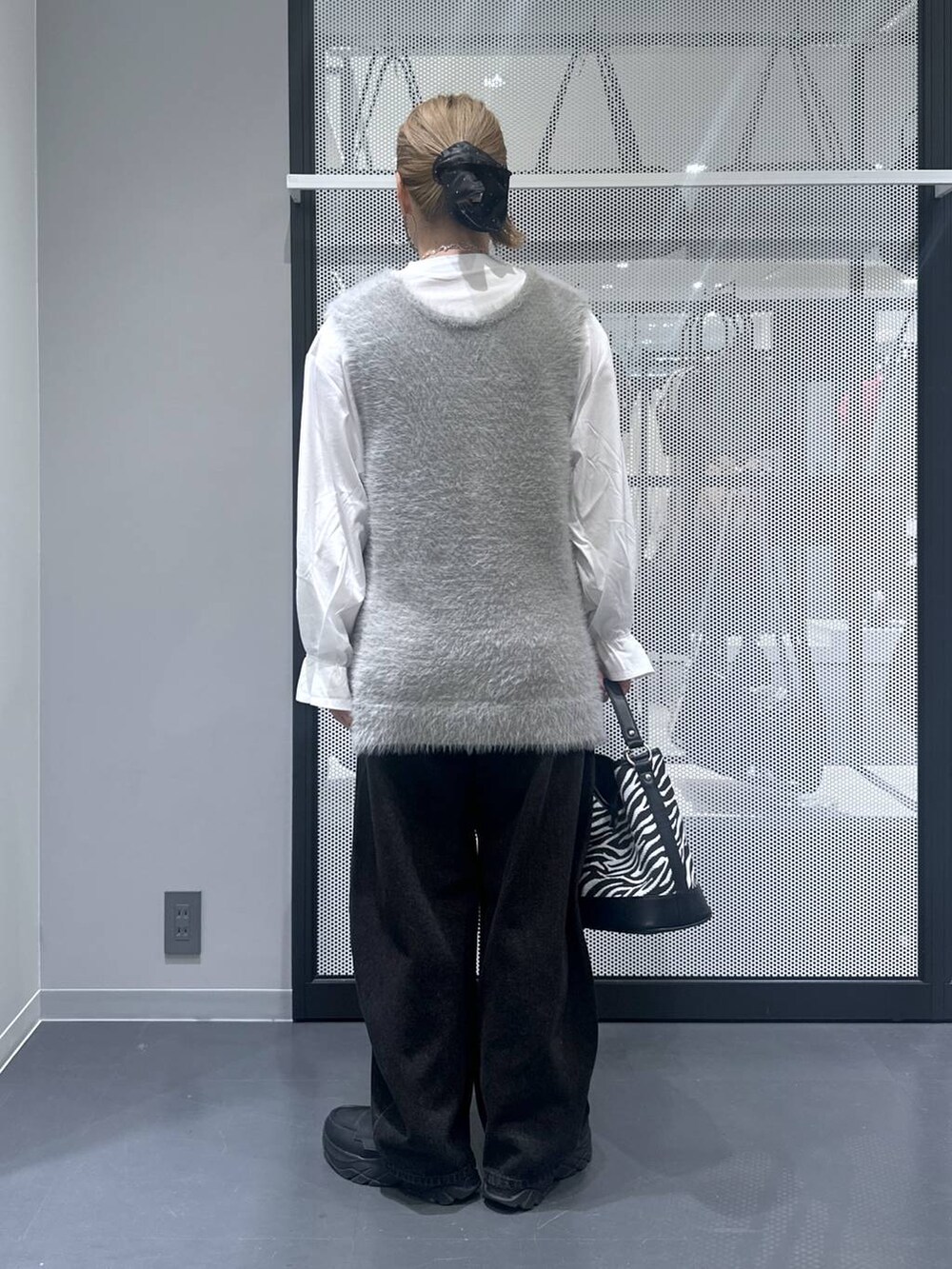 ブラック系のデニムパンツ、その他のショルダーバッグ、グレー系のベストを着用したレディースの秋コーディネートの3枚目の写真