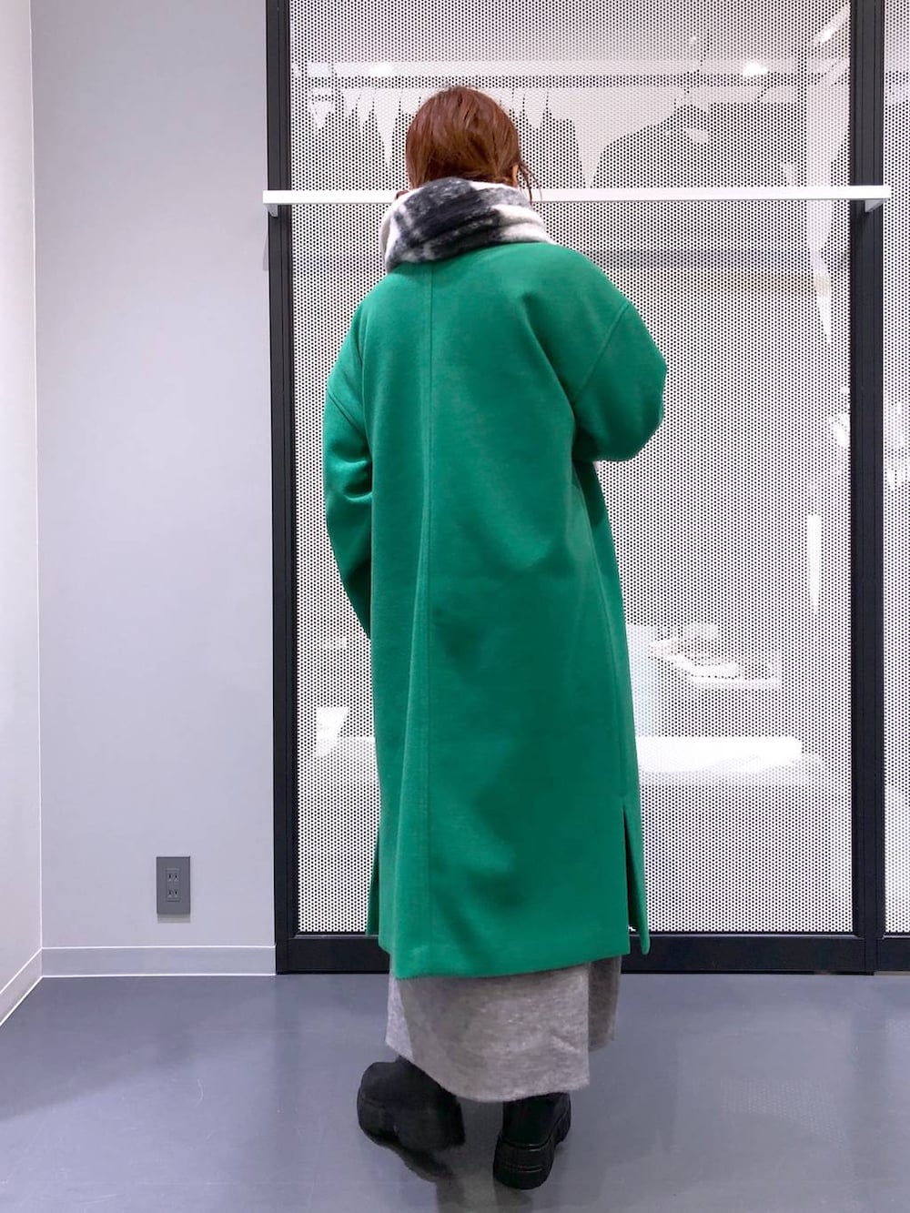 ブラック系のブーツ、シルバー系のショルダーバッグ、グリーン系のノーカラーコートを着用したレディースの冬コーディネートの4枚目の写真