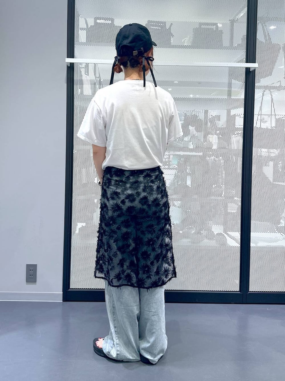 ブルー系のデニムパンツ、ホワイト系のTシャツ/カットソー、ブラック系のショルダーバッグを着用したレディースの夏コーディネートの3枚目の写真