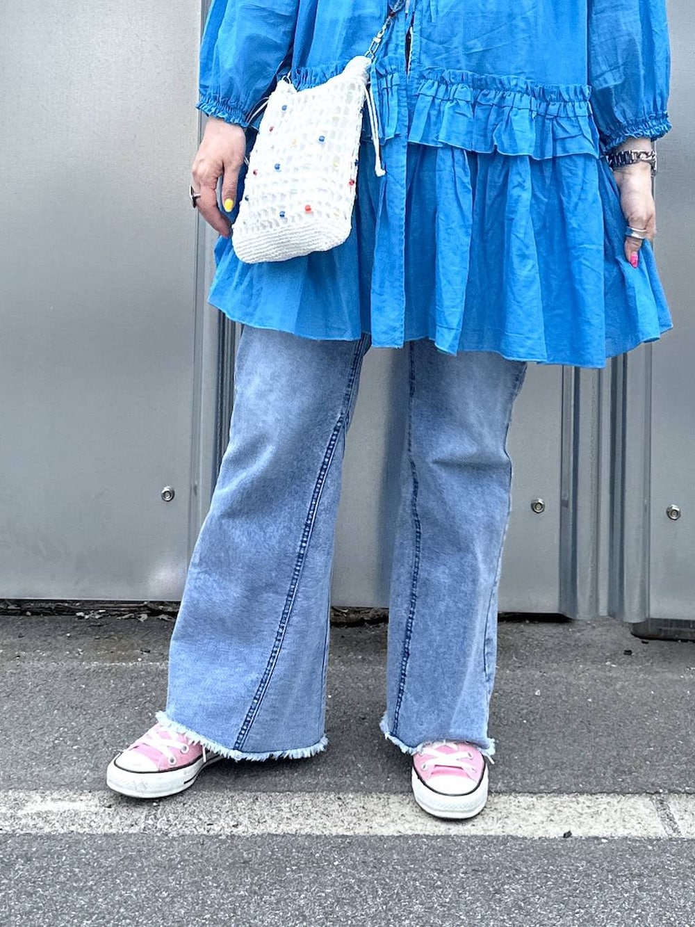 ブルー系のデニムパンツ、その他のショルダーバッグ、その他のピアス（両耳用）を着用したレディースの春コーディネートの4枚目の写真