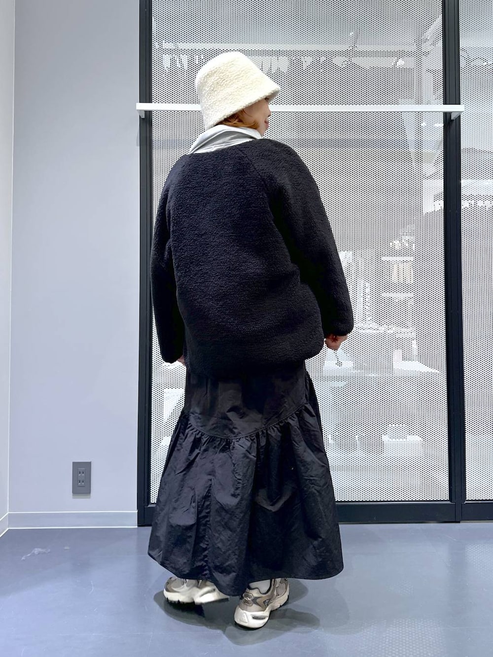 ブラウン系のスニーカー、ホワイト系のショルダーバッグ、その他のニット/セーターを着用したレディースの冬コーディネートの4枚目の写真