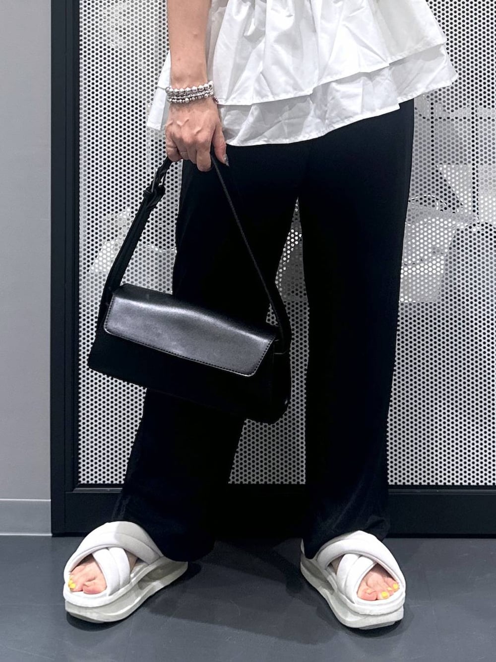 ブラック系のショルダーバッグ、ブラック系のその他パンツ、その他のピアス(両耳用)を着用したレディースの夏コーディネートの5枚目の写真