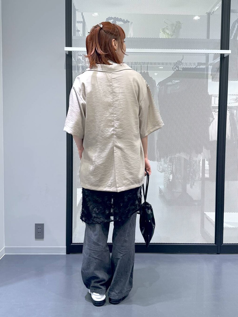 ブラック系のショルダーバッグ、ブラック系のデニムパンツ、ホワイト系のTシャツ/カットソーを着用したレディースの夏コーディネートの4枚目の写真