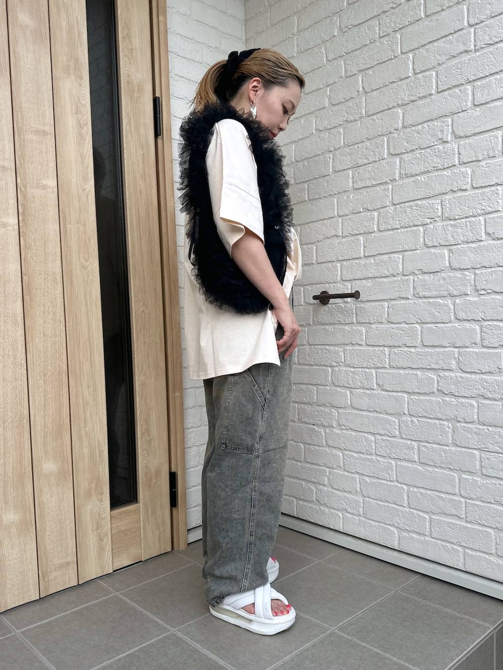 ブラック系のショルダーバッグ、ホワイト系のサンダル、その他のデニムパンツを着用したレディースの夏コーディネートの2枚目の写真