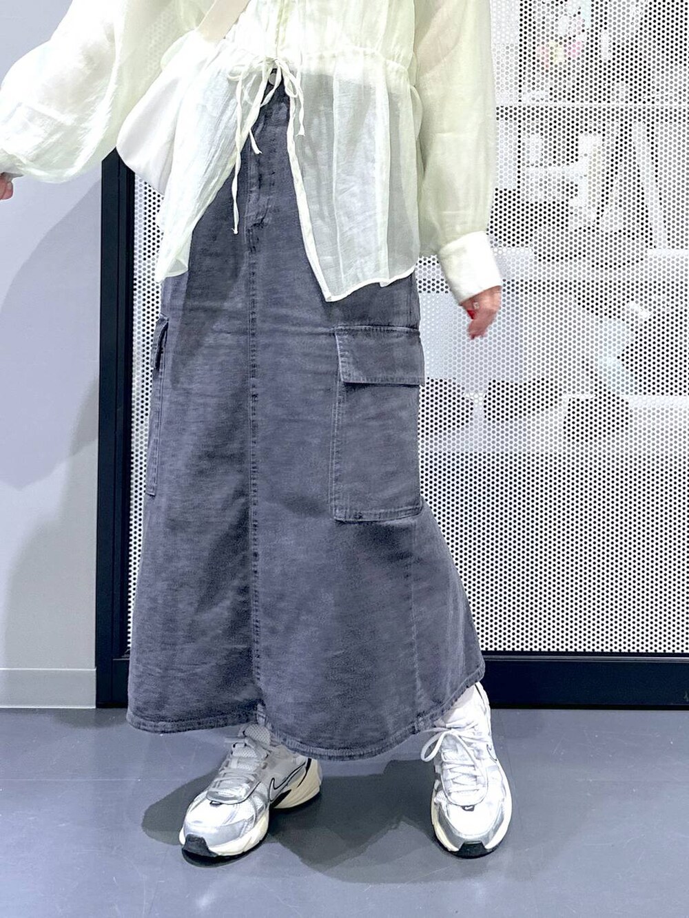 グレー系のデニムスカート、ホワイト系のTシャツ/カットソー、ホワイト系のショルダーバッグを着用したレディースの春コーディネートの7枚目の写真