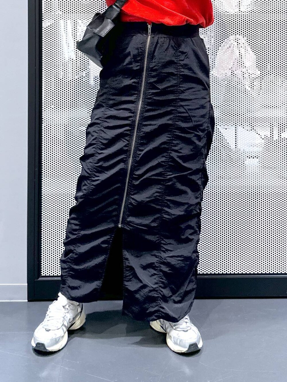 ブラック系のスカート、ブラック系のショルダーバッグ、レッド系のTシャツ/カットソーを着用したレディースの春コーディネートの5枚目の写真