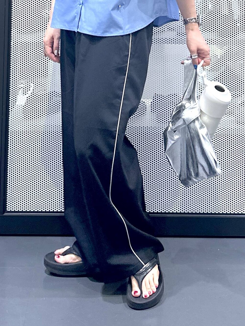 シルバー系のショルダーバッグ、ブラック系のスラックス、ブラック系のサンダルを着用したレディースの夏コーディネートの5枚目の写真