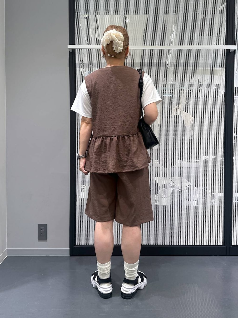 ホワイト系のTシャツ/カットソー、ブラック系のショルダーバッグ、ブラウン系のその他パンツを着用したレディースの夏コーディネートの2枚目の写真