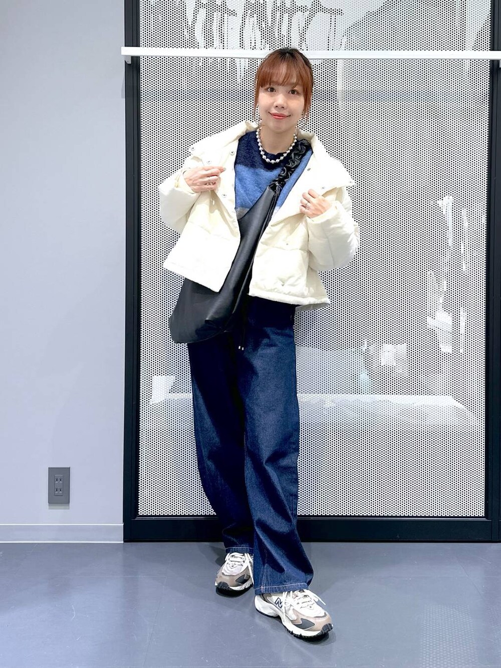 ブラウン系のスニーカー、ホワイト系のTシャツ/カットソー、ブルー系のデニムパンツを着用したレディースの冬コーディネートの7枚目の写真