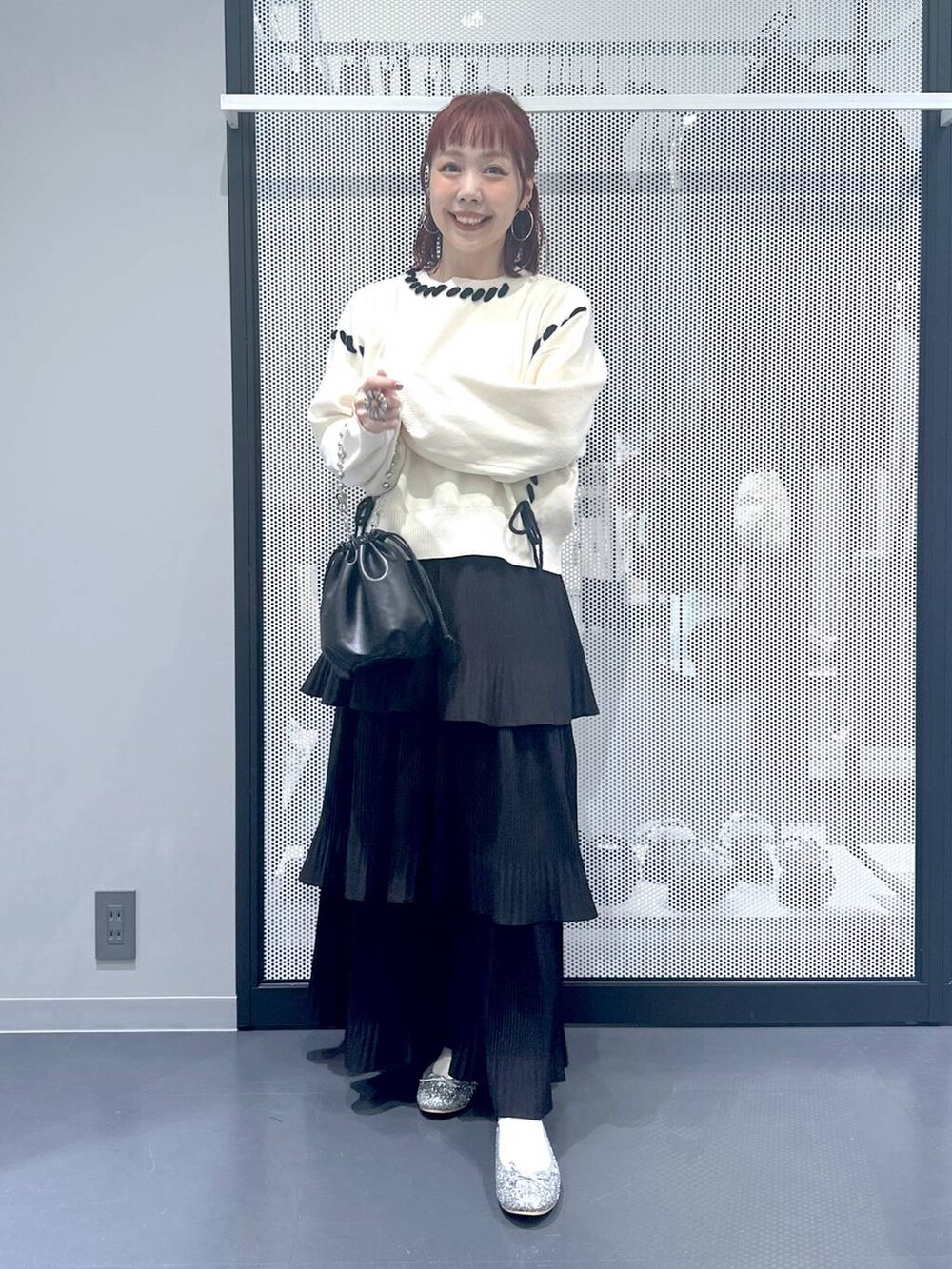 ブラック系のスカート、ブラック系のショルダーバッグ、シルバー系のパンプスを着用したレディースの秋コーディネートの6枚目の写真