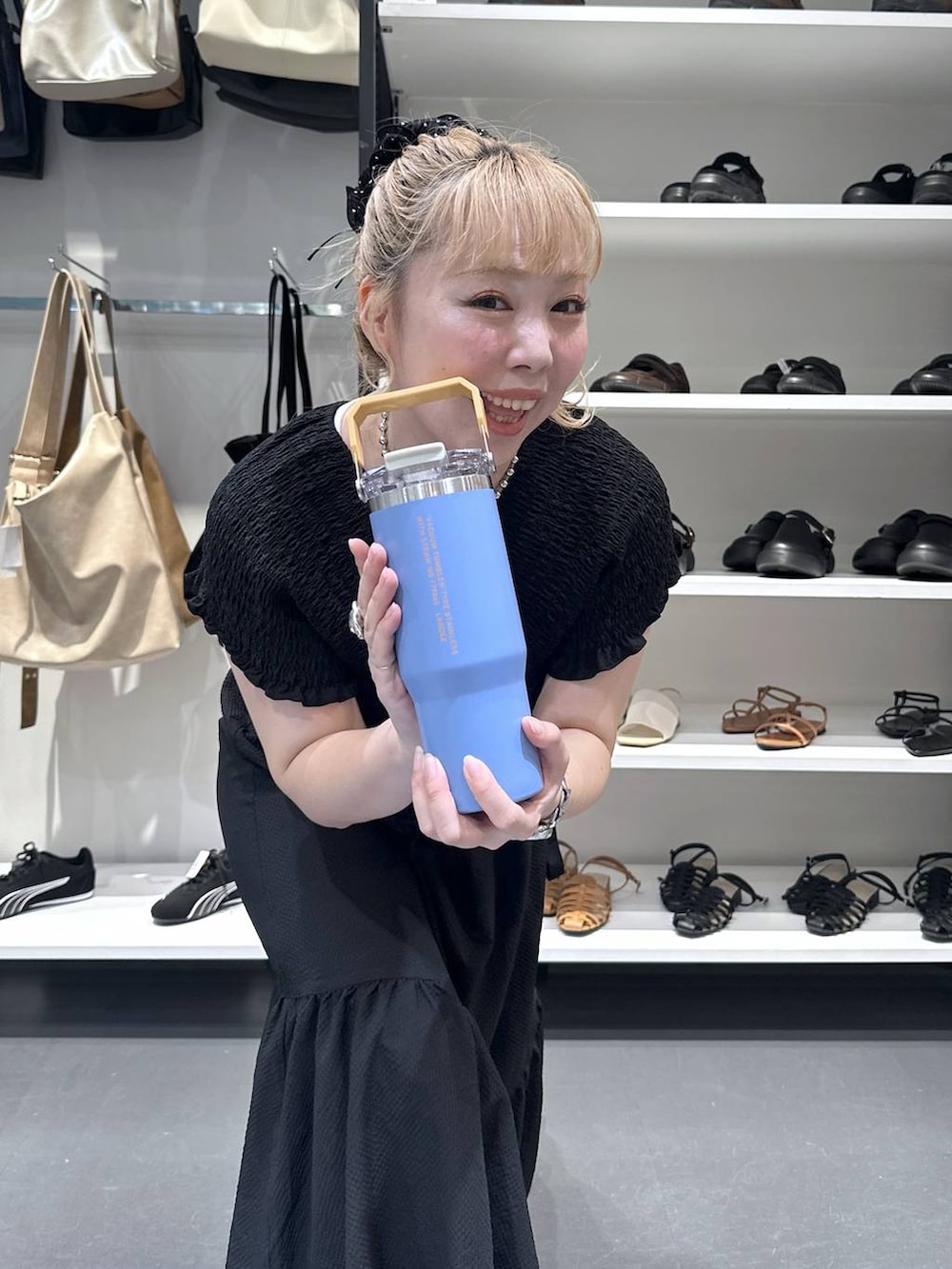ブラック系のワンピース、シルバー系のデジタル腕時計、オレンジ系の水筒を着用したレディースの夏コーディネートの6枚目の写真