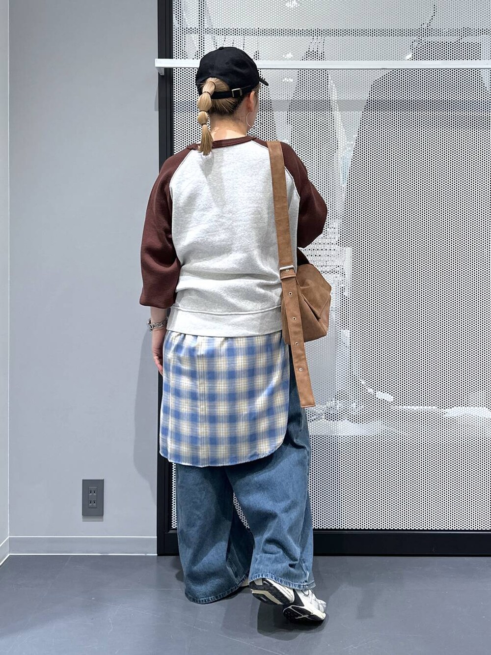 イエロー系のショルダーバッグ、ブルー系のデニムパンツ、ブラウン系のニット/セーターを着用したレディースの秋コーディネートの3枚目の写真