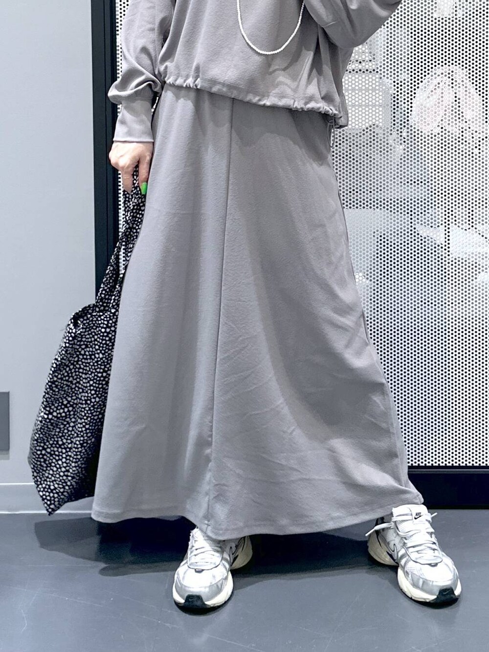 グレー系のスカート、グレー系のTシャツ/カットソー、ブラック系のトートバッグを着用したレディースの春コーディネートの5枚目の写真